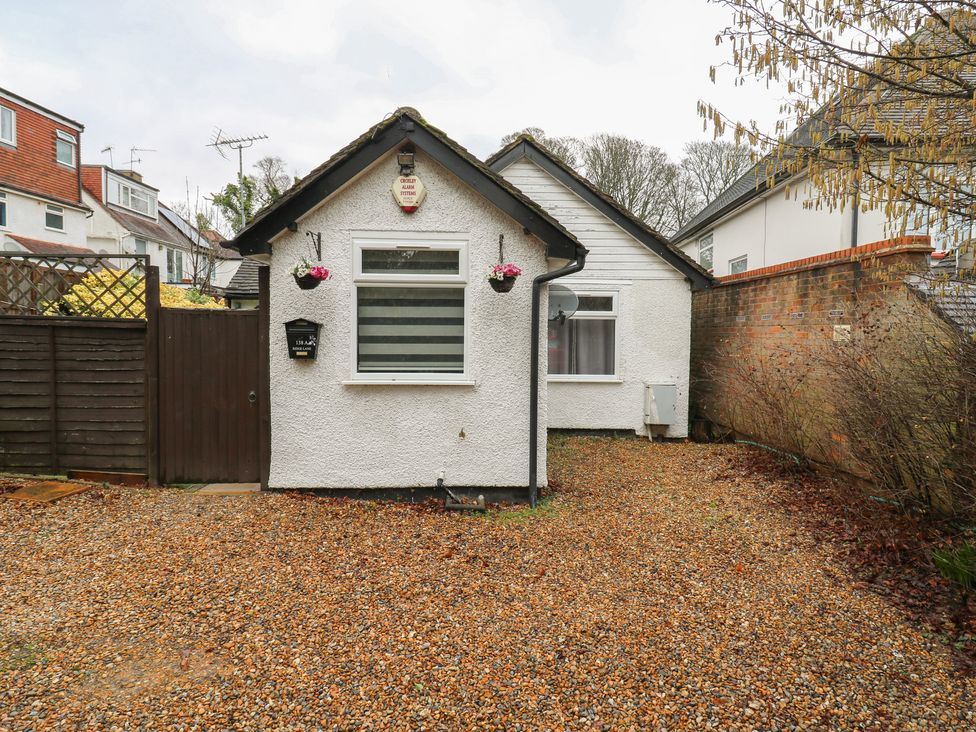 A house with a gravel area and a wooden gate at The Enchanted House in Watford
