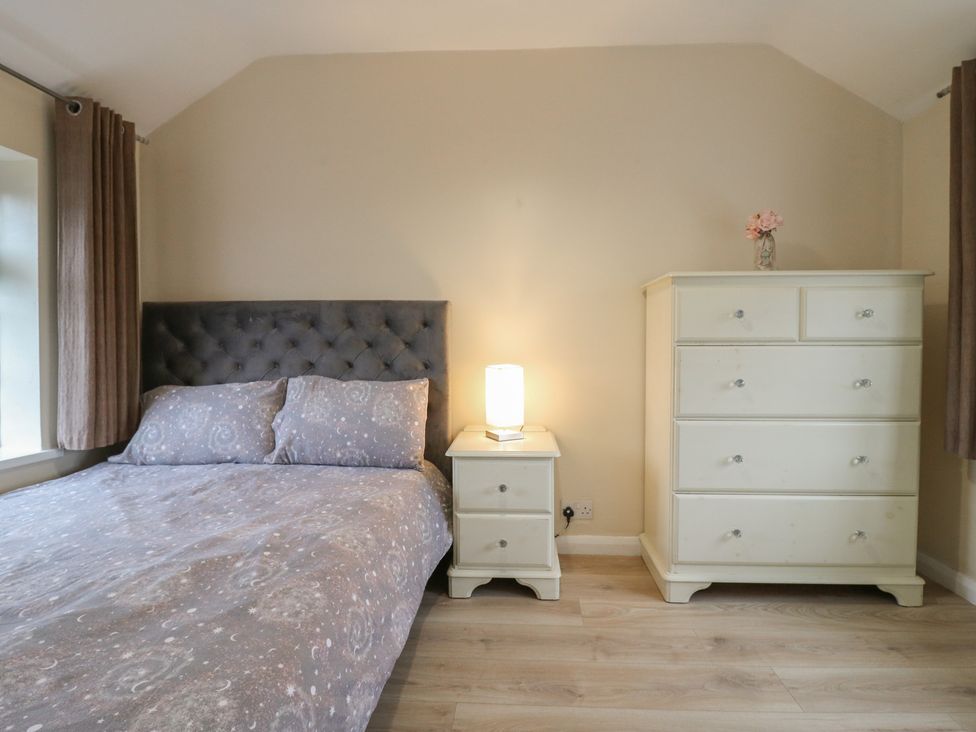 A bedroom with a bed and dresser at Headmasters Hollow in Watford