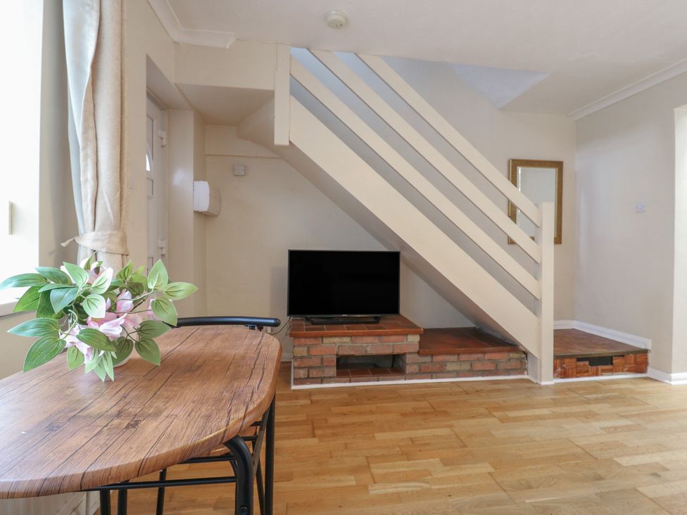 A living room with a table, plant, and tv at Headmasters Hollow in Watford