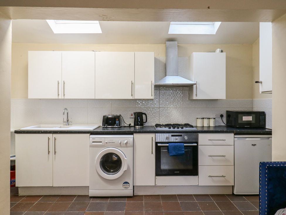 A kitchen with cabinets, sink, stove, washing machine at Headmasters Hollow in Watford