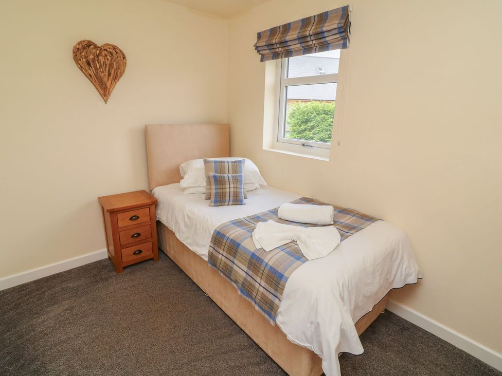 A bedroom with a single bed and bedside table at James Ville Marina Lodge 7 in Brigg