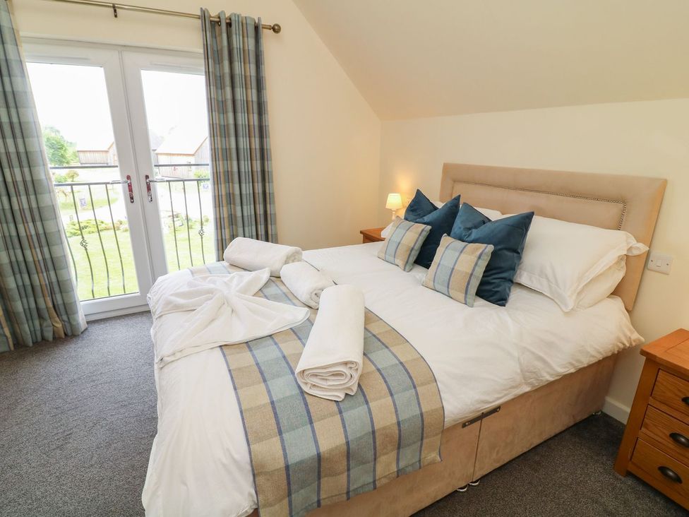 A bedroom with a bed and balcony doors at James Ville Marina Lodge 7 in Brigg