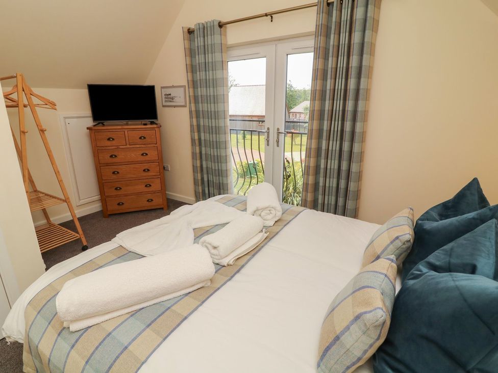 A bedroom with a bed and television at James Ville Marina Lodge 7 Brigg