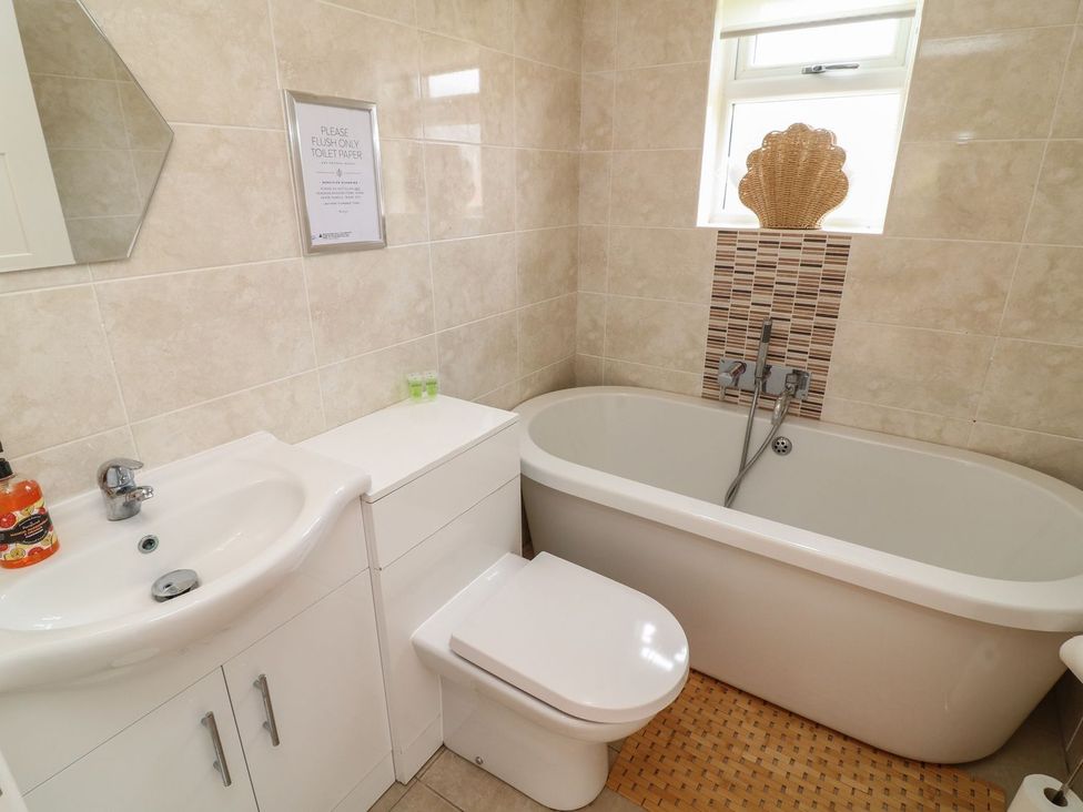 A bathroom with a bathtub, wash basin, and toilet at James Ville Marina Lodge 7, Brigg