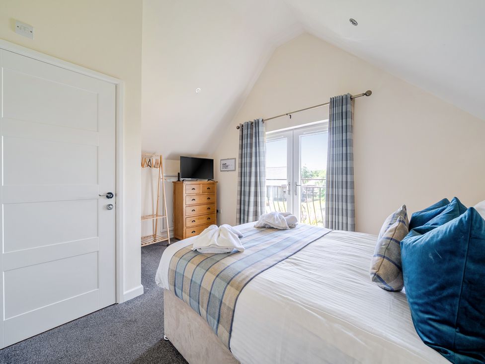 A bedroom with a bed and a dresser at James Ville Marina Lodge 7 in Brigg