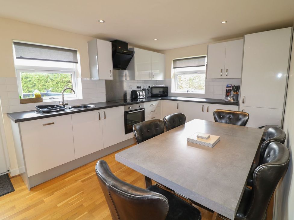 A kitchen with a table and chairs at James Ville Marina Lodge 8 in Brigg