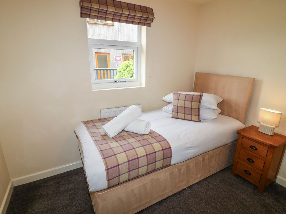 A bedroom with a single bed and bedside table at James Ville Marina Lodge 8 in Brigg