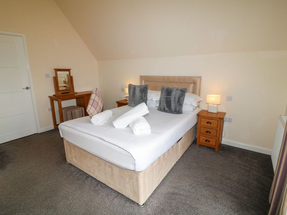 A bedroom with a bed and a mirror at James Ville Marina Lodge 8 in Brigg