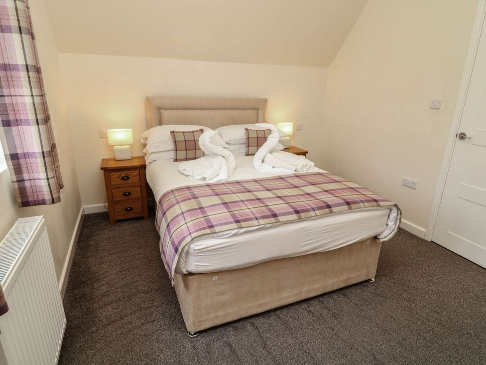 A bedroom with a bed and bedside table at James Ville Marina Lodge 8 in Brigg
