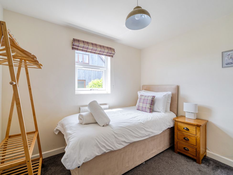 A bedroom with a single bed and clothes rack at James Ville Marina Lodge 8 in Brigg