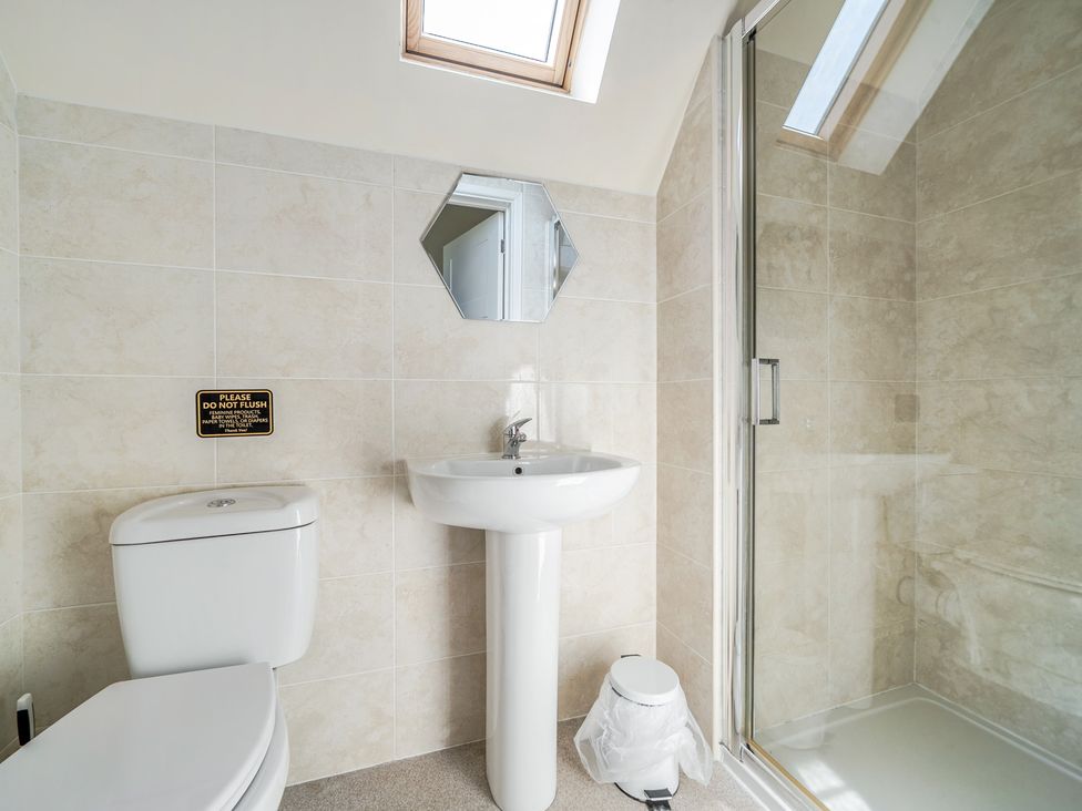 A bathroom with a toilet, sink, and shower at James Ville Marina Lodge 8 in Brigg