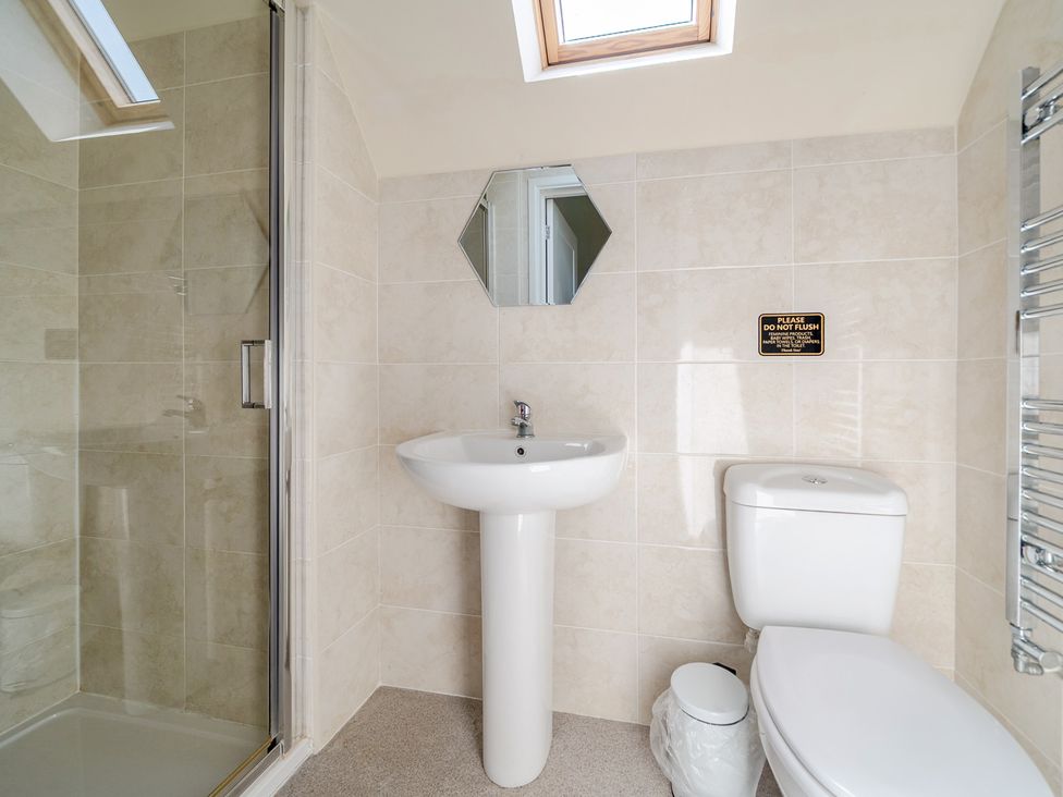 A bathroom with a shower, sink, and toilet at James Ville Marina Lodge 8 in Brigg