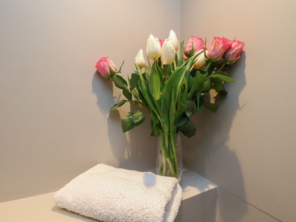 A vase with tulips and a towel at South Villa Sandsend near Whitby