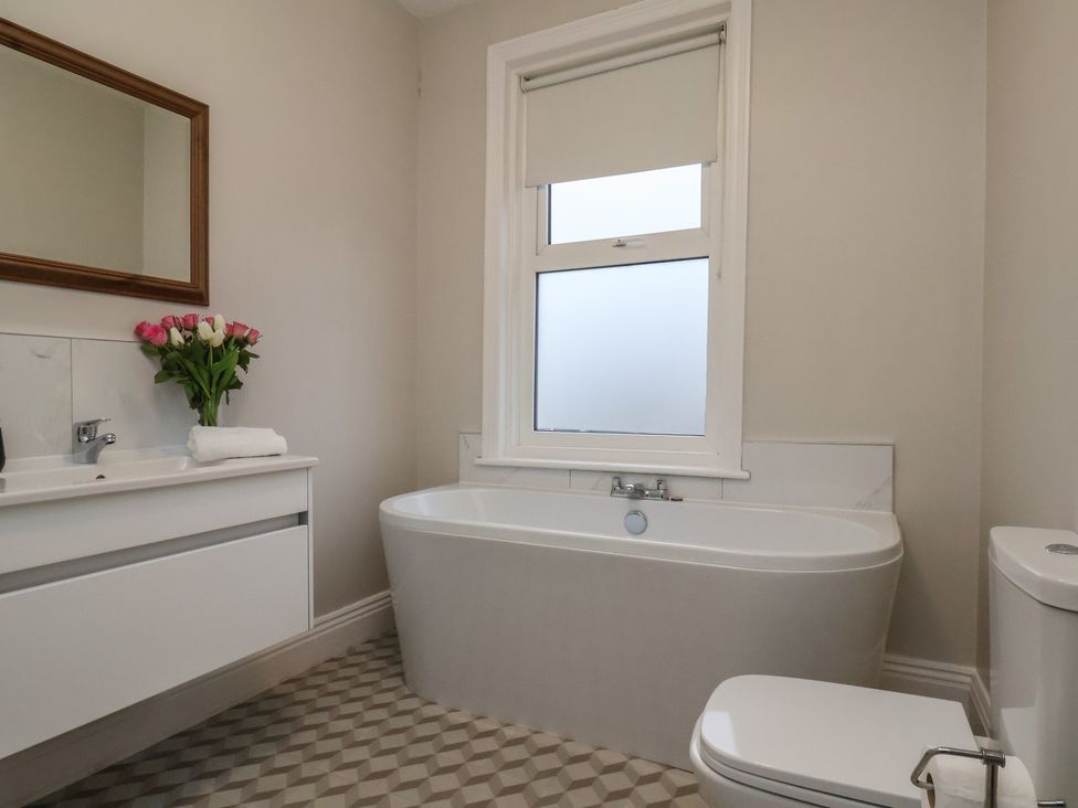 A bathroom with a bathtub, sink, and toilet at South Villa in Sandsend near Whitby