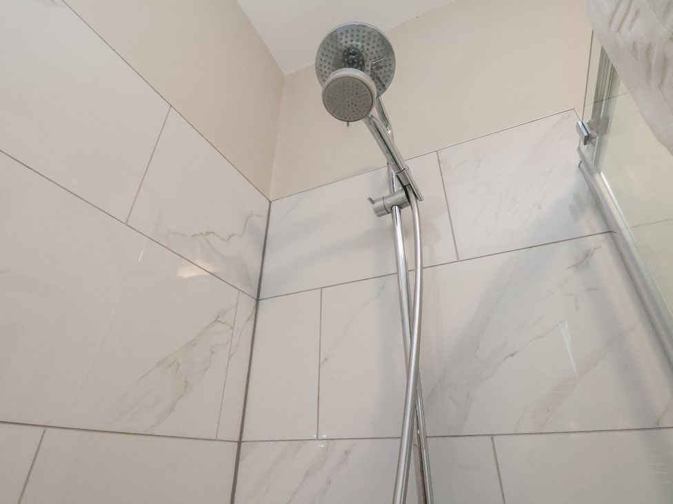 A showerhead and wall tiles at South Villa in Sandsend near Whitby