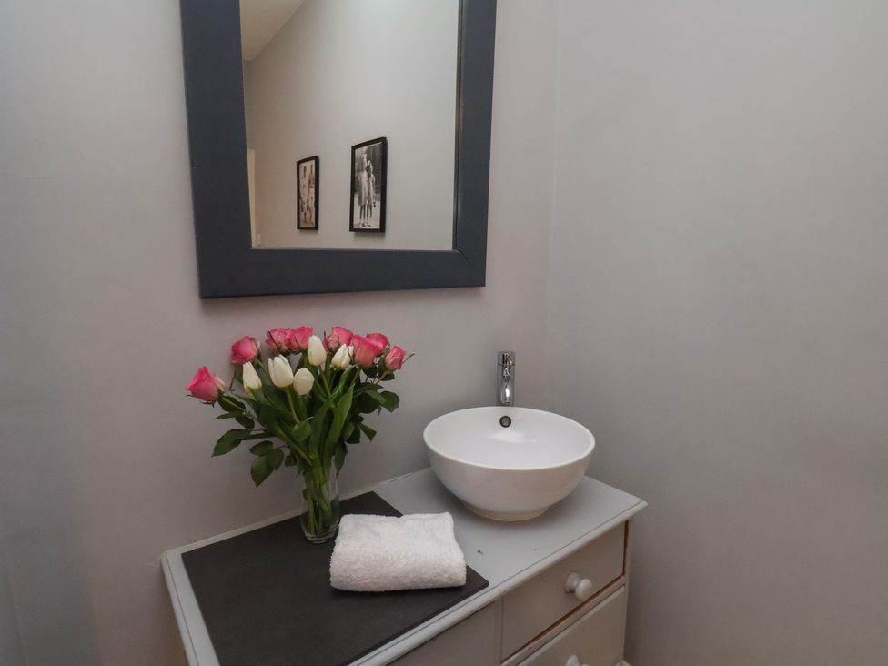 A bathroom with a sink and flowers at South Villa Sandsend near Whitby