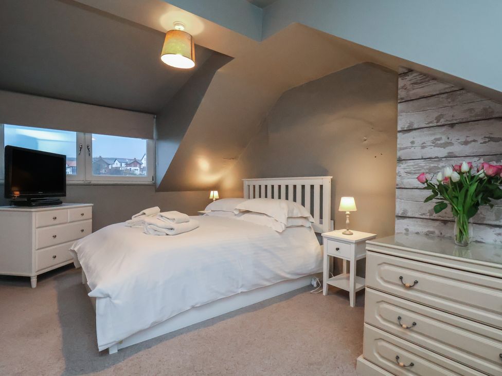 A bedroom with a bed and television at South Villa Sandsend near Whitby