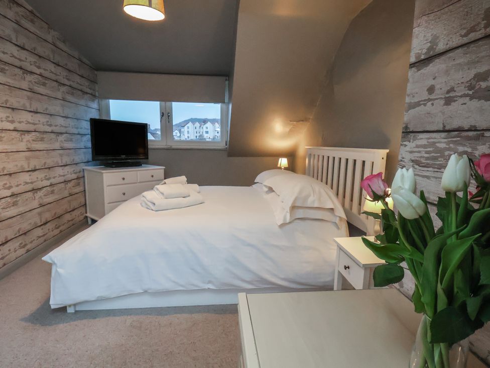 A bedroom with a bed and television at South Villa in Sandsend near Whitby