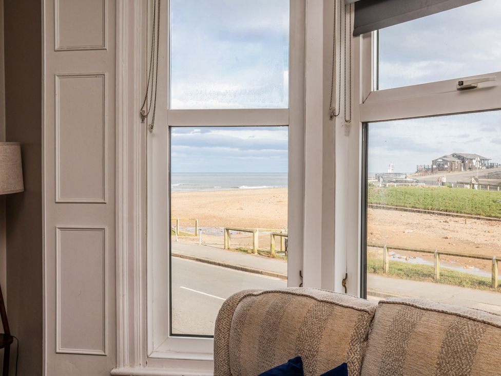 A living room with a beach view at South Villa Sandsend near Whitby