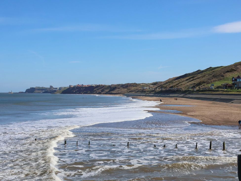 A beach with waves and cliffs at South Villa Sandsend near Whitby