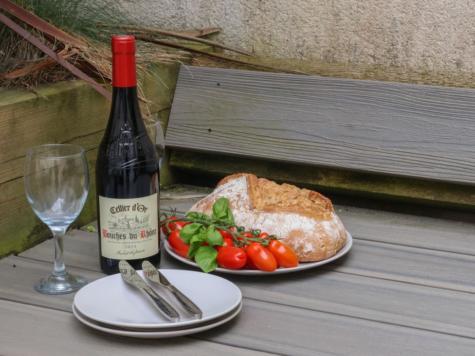 An outdoor area with wine, bread, tomatoes, and glass at South Villa in Sandsend near Whitby