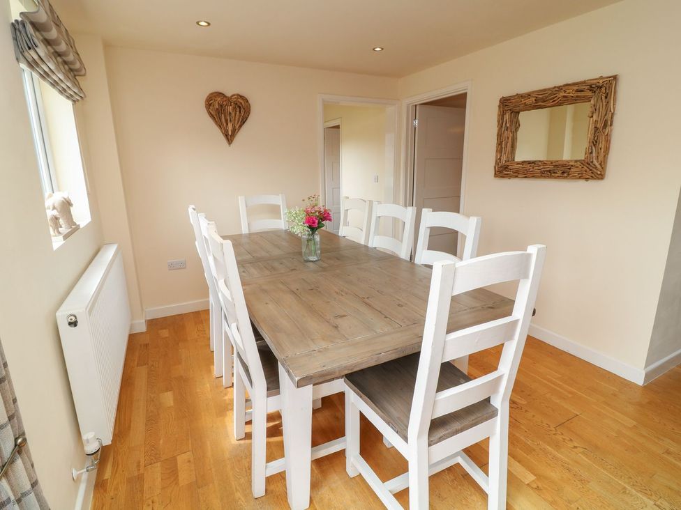 A dining room with a wooden table and chairs at James Ville Marina Lodge 9 in Brigg