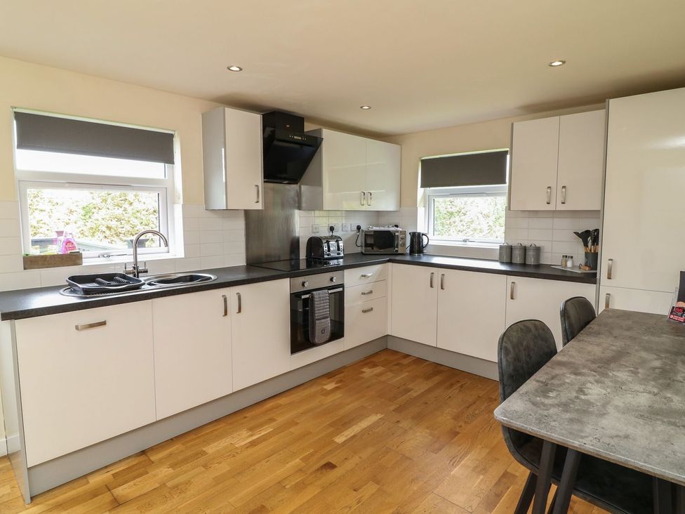 A kitchen with appliances and a dining table at James Ville Marina Lodge 9 in Brigg