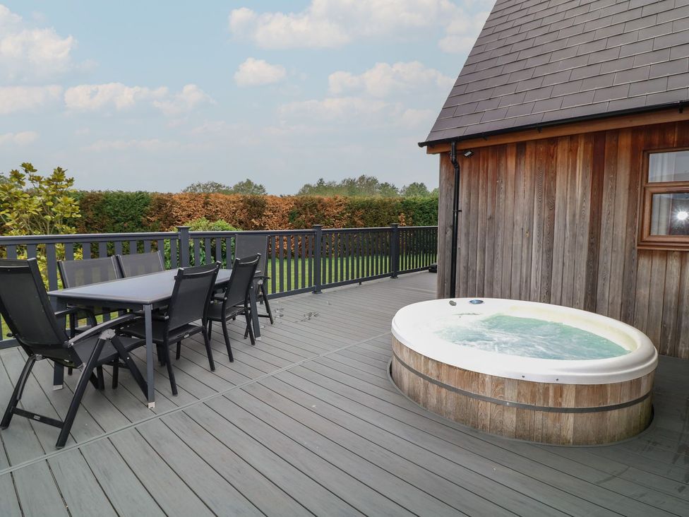 An outdoor area with a table and chairs alongside a hot tub at James Ville Marina Lodge 9 in Brigg