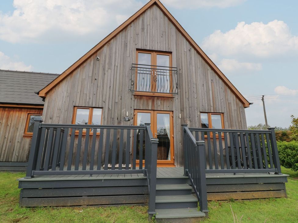 A wooden house with a balcony and steps at James Ville Marina Lodge 9 in Brigg