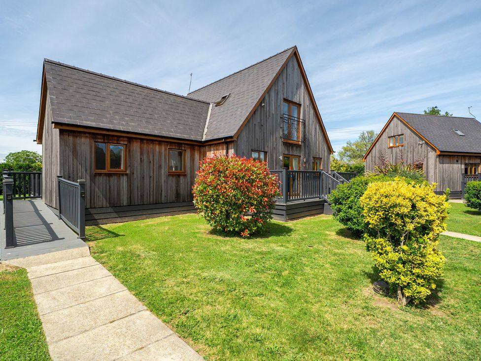 A wooden house with a balcony and garden at James Ville Marina Lodge 9 Brigg