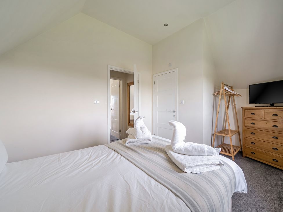 A bedroom with a bed and towels at James Ville Marina Lodge 9 Brigg