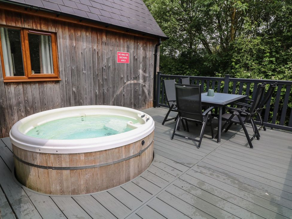 An outdoor area featuring a hot tub and a table with chairs at James Ville Marina Lodge 13 in Brigg
