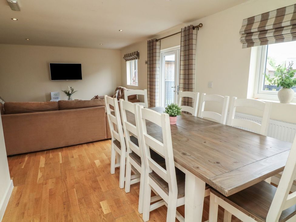 A dining area with a table and chairs at James Ville Marina Lodge 13 in Brigg