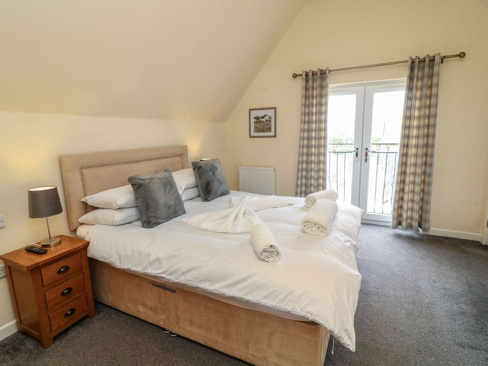 A bedroom with a bed and bedside table at James Ville Marina Lodge 13 in Brigg
