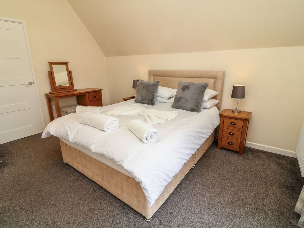 A bedroom with a bed and bedside tables at James Ville Marina Lodge 13 in Brigg