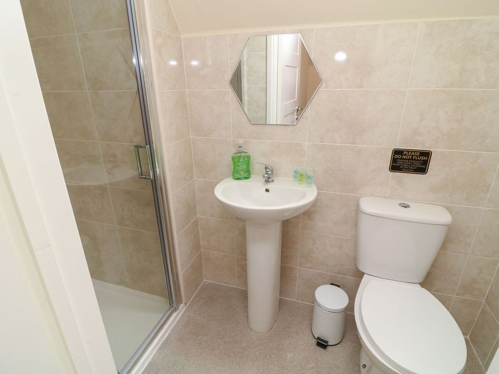 A bathroom featuring a shower, sink, and toilet at James Ville Marina Lodge 13 in Brigg