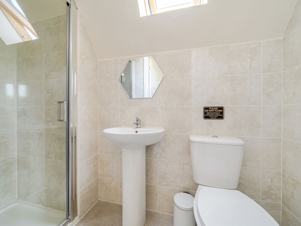 A bathroom with a shower, sink, and toilet at James Ville Marina Lodge 13 in Brigg