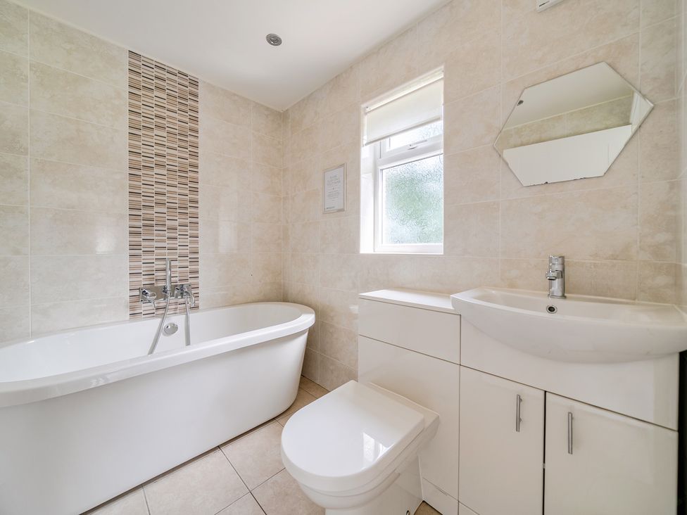 A bathroom with a bathtub, toilet, sink and mirror at James Ville Marina Lodge 13 in Brigg