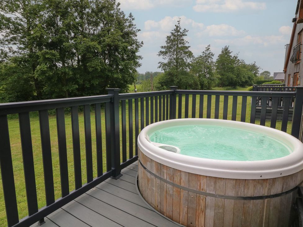 An outdoor area with a hot tub on a deck at James Ville Marina Lodge 14 in Brigg