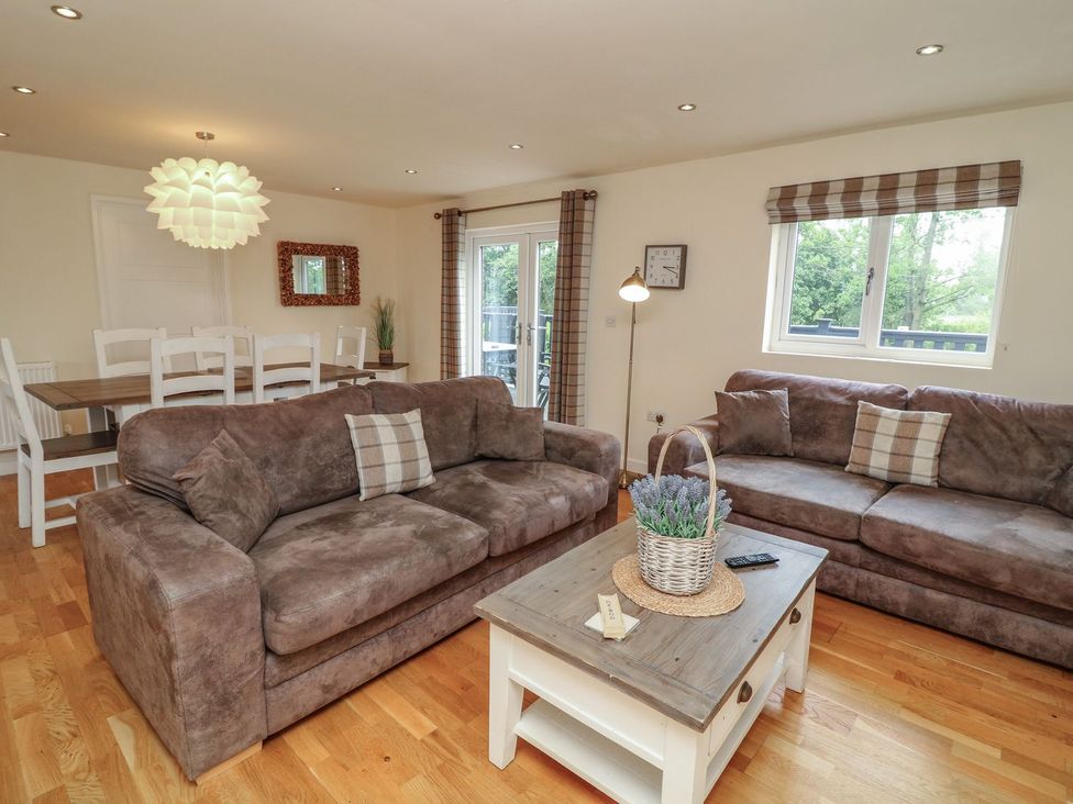 A living room with sofas and a dining area at James Ville Marina Lodge 14 in Brigg