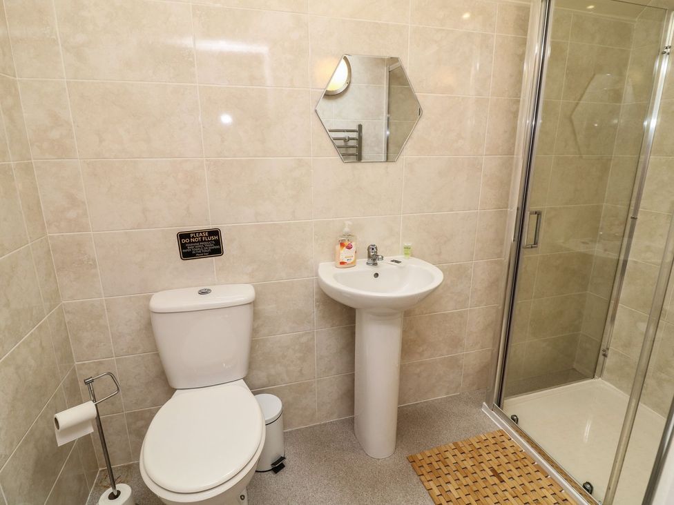 A bathroom with a toilet, sink, and shower at James Ville Marina Lodge 14 in Brigg