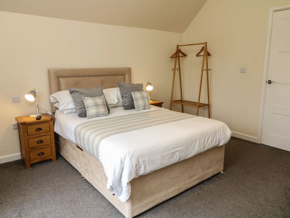 A bedroom with a bed and nightstand at James Ville Marina Lodge 14 in Brigg