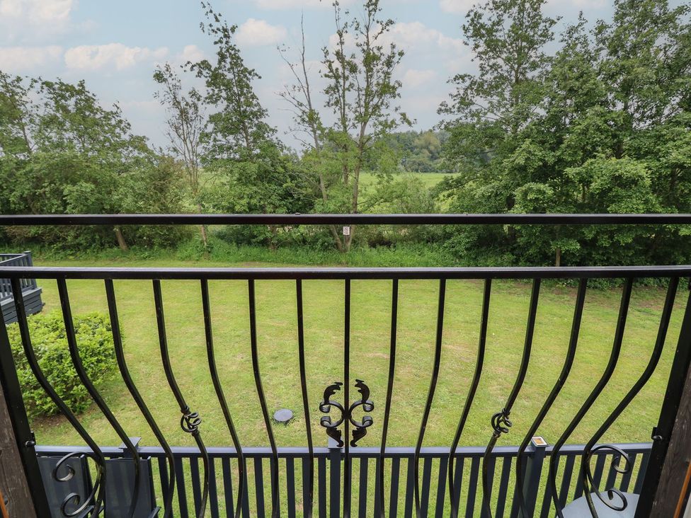 A view from a balcony overlooking grass and trees at James Ville Marina Lodge 14 in Brigg
