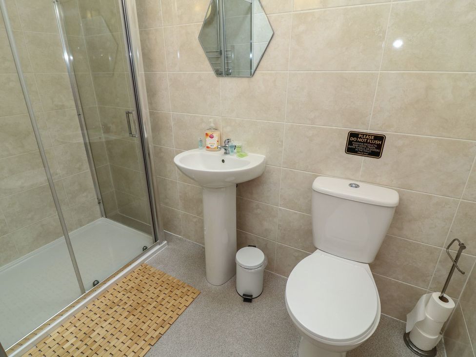 A bathroom with a shower, washbasin, and toilet at James Ville Marina Lodge 14 in Brigg