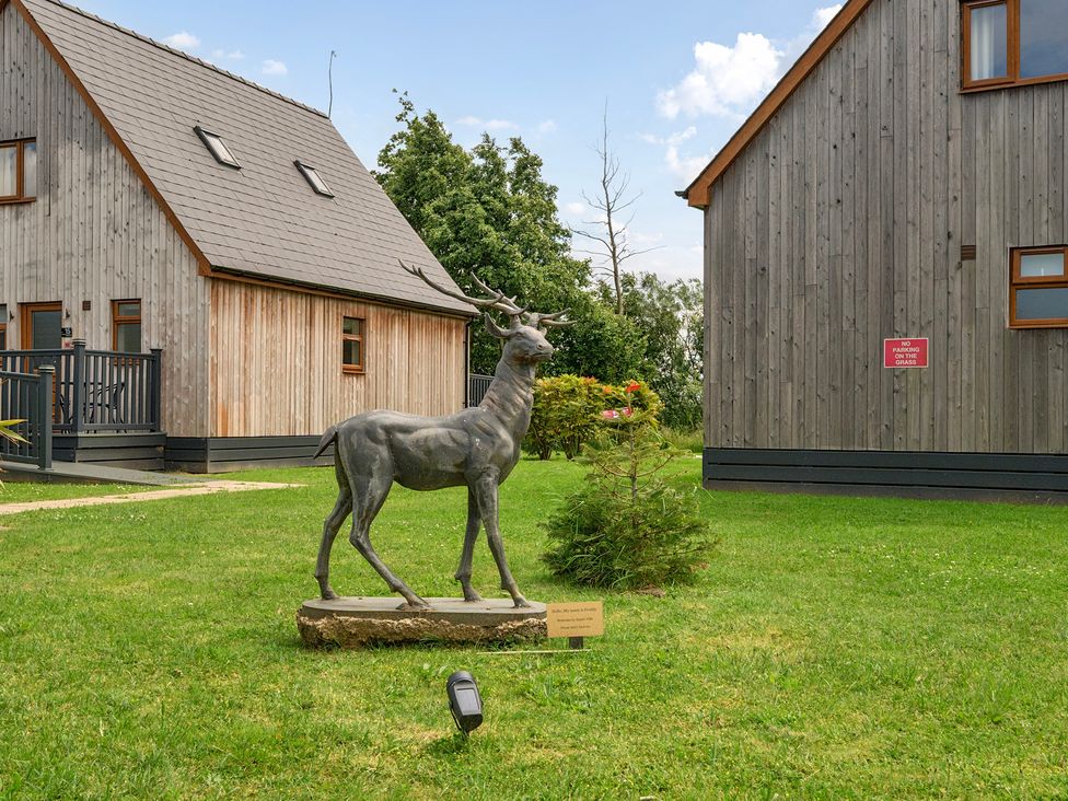 A statue in a garden with houses in the background at James Ville Marina Lodge 14 Brigg