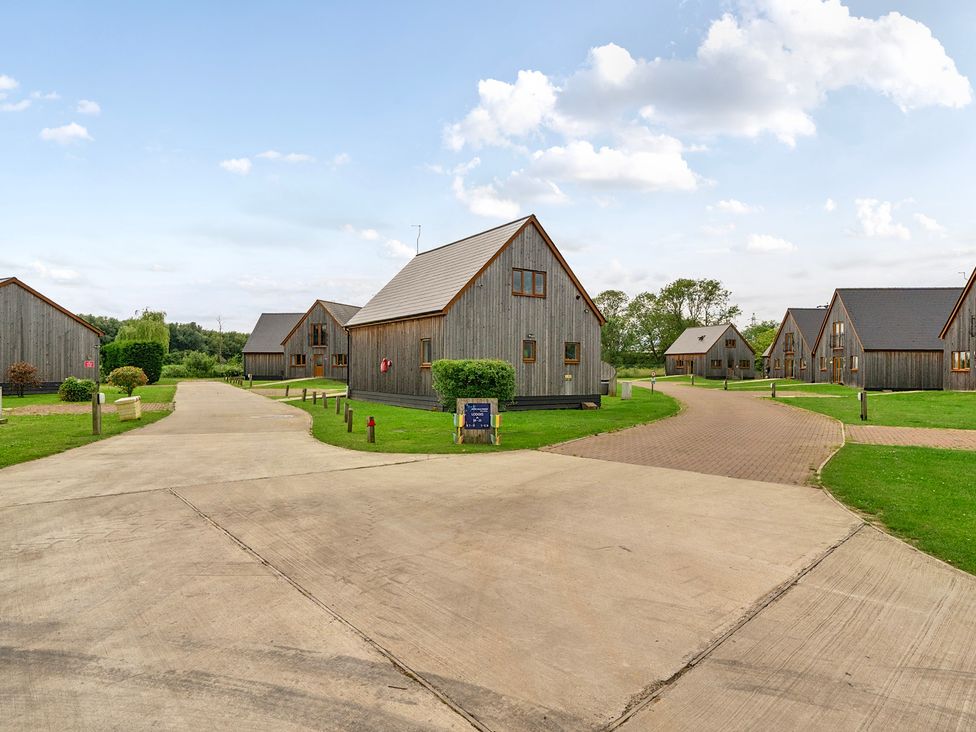 An outdoor view of wooden cabins and a road at James Ville Marina Lodge 14 in Brigg