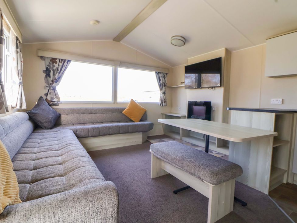 A living room with a sofa and table at Dunes View in Prestatyn