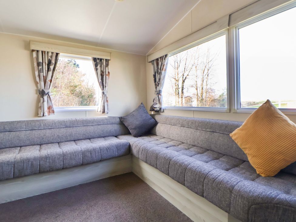 A living room with a sofa and windows at Dunes View in Prestatyn
