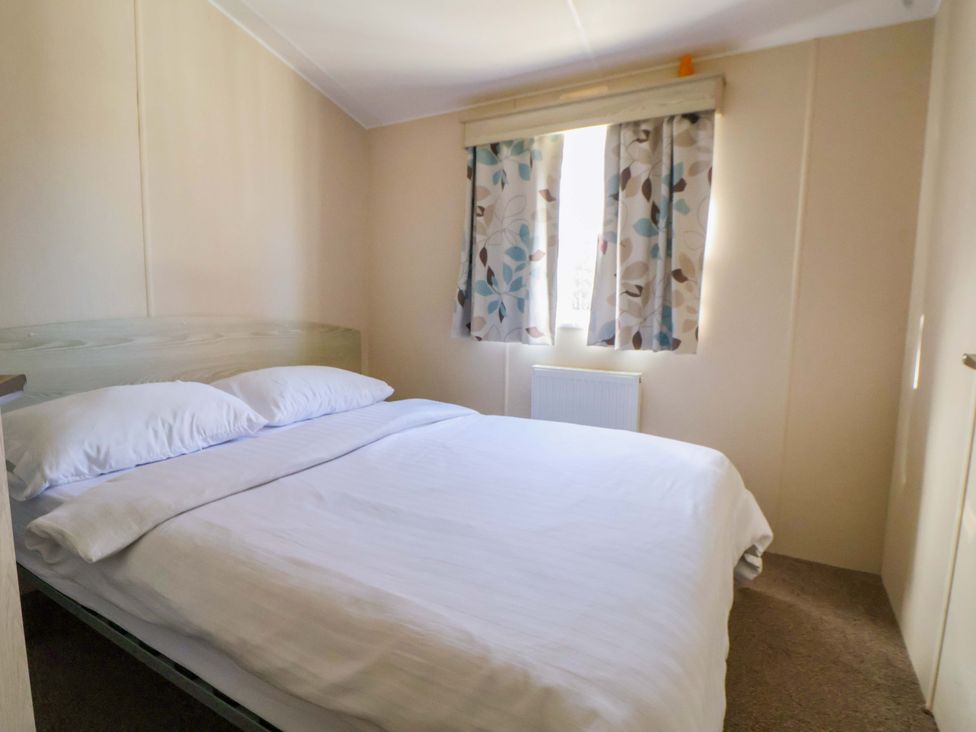 A bedroom with a bed and curtains at Dunes View in Prestatyn