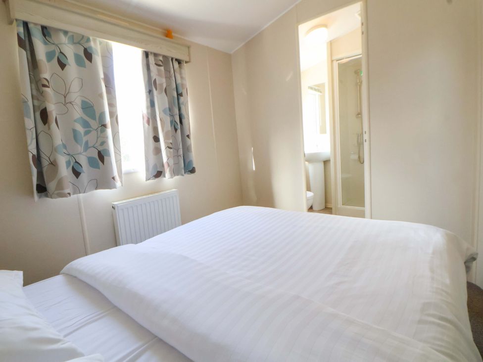 A bedroom with a bed and curtains at Dunes View in Prestatyn